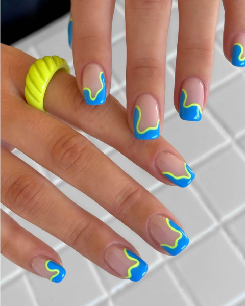 Squiggly blue and neon yellow French tips on nude nail base.
