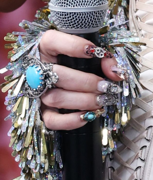 Jessica Simpson's hand wearing westerninspired nail art and jewelry