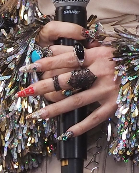 Jessica Simpson's hand wearing westerninspired nail art and jewelry