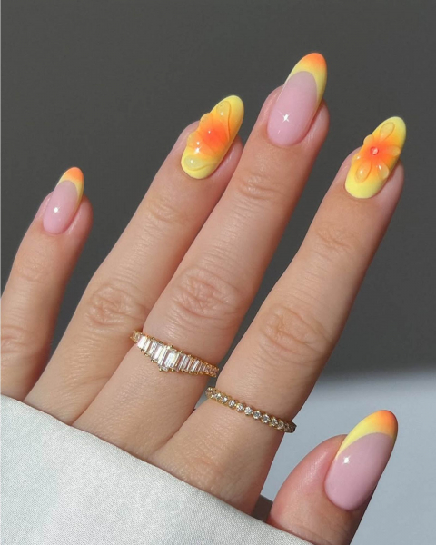 Orange and yellow aura acrylic nails with almond shape and clear gel flower designs.