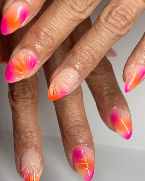 Pink and orange aura neon nails on a nude base with raised gel flower art.