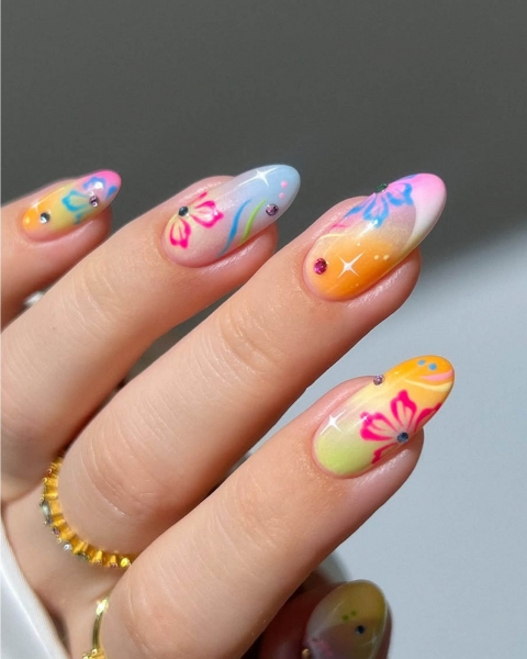 Multicolored tropicalthemed neon nails which scattered gems and sparkly details.
