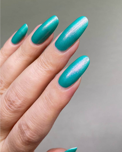 Long shimmery roundedtip neon teal acrylic nails point up and out.