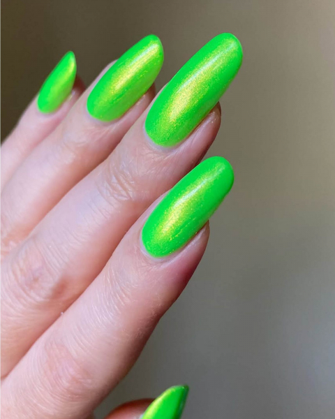 Long shimmery neon green roundedtip acrylic nails point out and up.